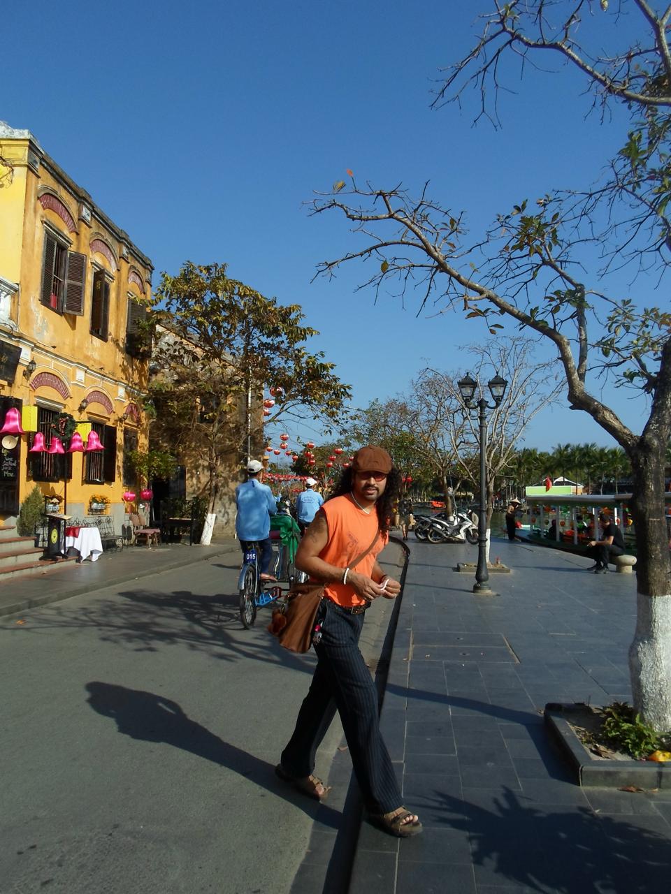 Eklavya walking down a sunlit street in Hoi An, Vietnam